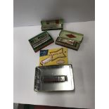 A box containing four various harmonicas to include a Reinhold Fridel World Star,