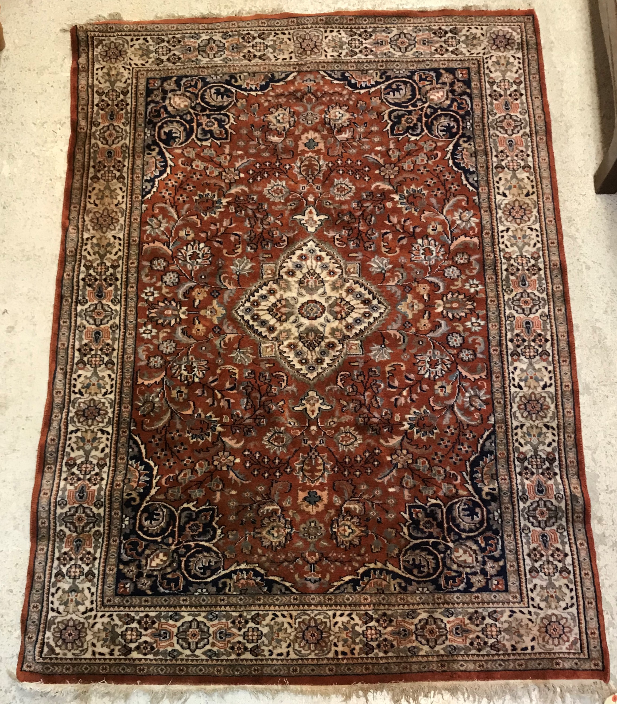 A Persian rug, the central panel set with floral decorated medallion on a brown ground,