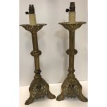 A pair of 19th Century pierced brass candlesticks converted to electric, with painted highlights,