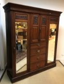 A late Victorian walnut wardrobe compactum with two cupboard doors over four drawers flanked by two