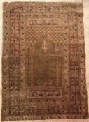 A vintage Ushak prayer rug, the central panel set with Mirhab design on a green ground,