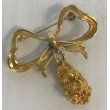 An 18 carat gold nugget and bow brooch, 4 cm long,