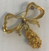 An 18 carat gold nugget and bow brooch, 4 cm long,