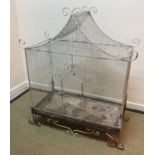 A vintage wirework and wrought iron framed birdcage with scrollwork decoration,