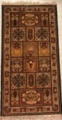 A Persian style rug, the central panel set with floral decorated tile motifs on a dark brown ground,