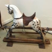 A Victorian dapple painted rocking horse in the manner of FH Ayres with deep studded brown leather