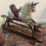 A Victorian dapple painted rocking horse in the manner of FH Ayres with deep studded brown leather