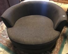 A large charcoal grey upholstered swivel "Cuddle" chair,