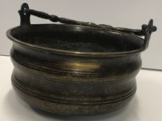 A 19th Century bronze bowl of circular ribbed form with swing handle,