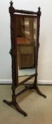 A 19th Century mahogany framed cheval mirror with turned and ringed decoration raised on splayed