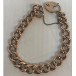 A 9 carat gold hoop link bracelet with heart shaped lock,