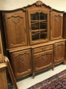 An oak side cabinet in the 18th Century style the upper section with glazed and barred door