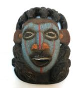 A wooden tribal mask with beaded decorat