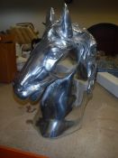 A polished aluminium horse head ornament