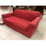 A modern red upholstered scroll arm two