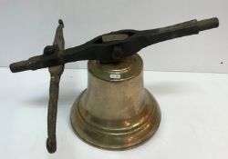 A cast metal bell with cast iron hanging
