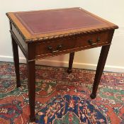 A 20th Century mahogany writing table with tooled and gilded leather insert top and gadrooned edge