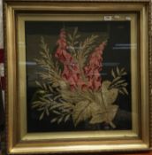 A tapestry picture depicting Foxgloves on a black and green ground, framed and glazed,