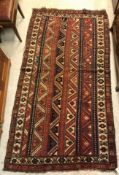 A vintage Caucasian carpet, the central panel set with striped design in blue, red and brown,