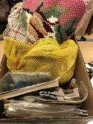 A box of assorted tapestry wool and part done tapestries,
