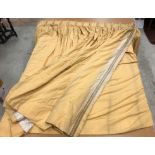 A pair of yellow cotton interlined curtains with braided edging and with taped triple pencil pleat