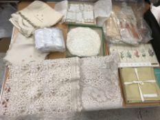 Two boxes of assorted table linens to include crocheted doilies, serviettes, tray cloths, etc,