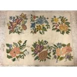 A 20th Century wool cross stitch on canvas rug with floral decoration on a cream ground,