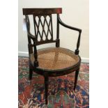 An early 19th Century black lacquered and chinoiserie decorated cane seated elbow chair on turned
