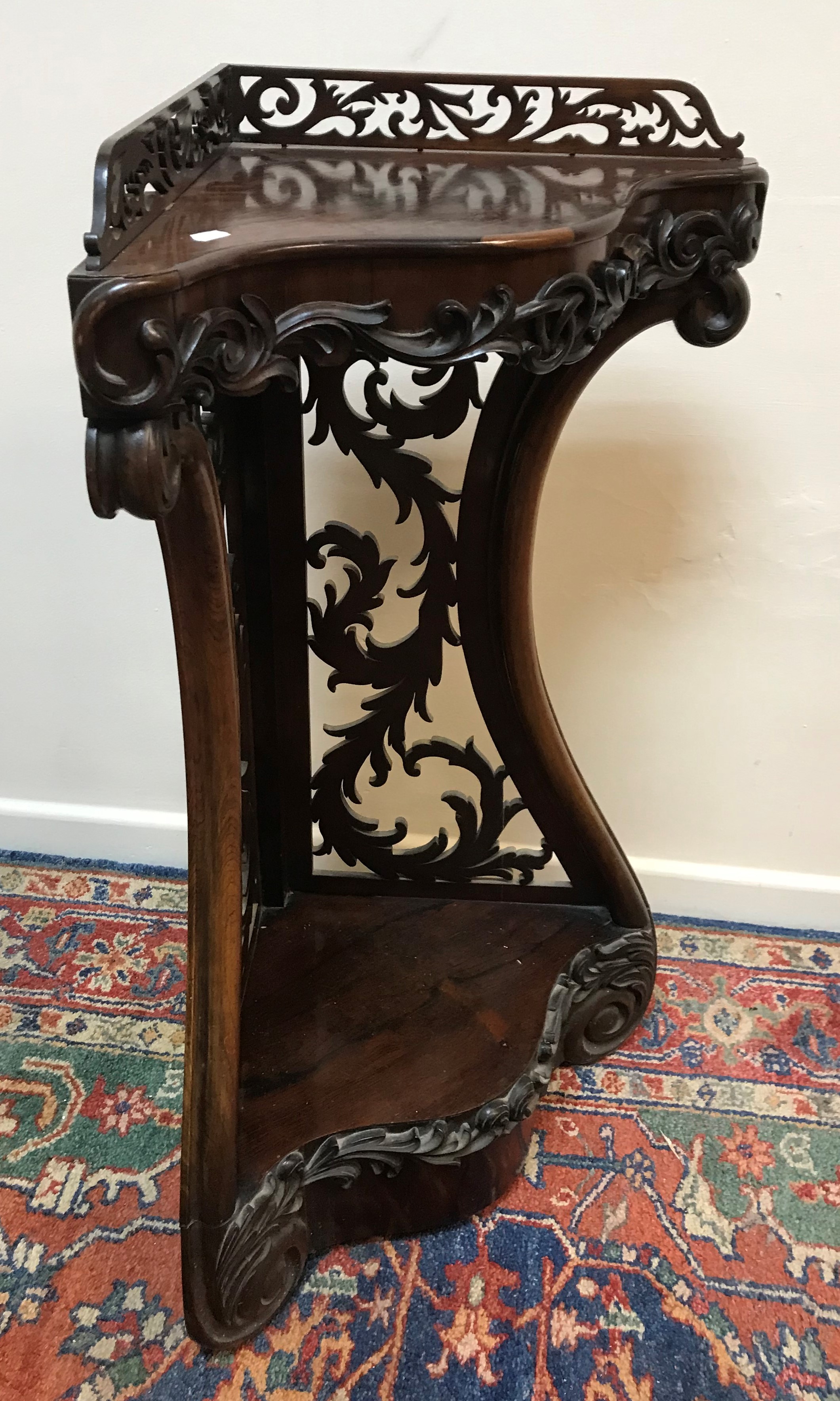 A Victorian rosewood corner shelf with fretwork galleried back over a serpentine front with applied