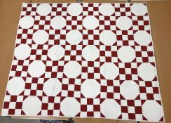 A red and white nine patch / snowball pattern quilt,