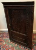 An early 18th Century oak hanging corner cupboard,