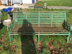 A Victorian cast iron slatted garden bench seat on scrollwork decorated ends 183 cm wide x 84 cm