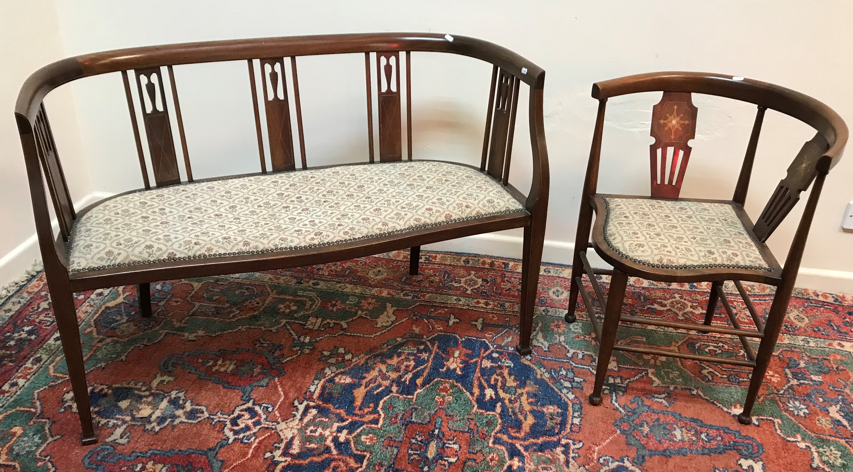 An Edwardian mahogany and inlaid two seat salon settee on square tapered legs to splayed feet,