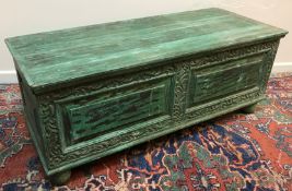 A modern Indian carved and green painted hardwood coffer, the plain top over two fielded panels,