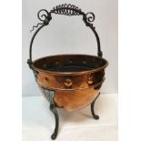 A Victorian embossed copper coal bucket with scrollwork decorated wrought iron handle raised on