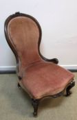 A Victorian walnut framed spoon back salon chair with carved decoration and upholstered back and