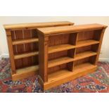 A pair of modern stained pine open bookcases of two banks of three shelves, raised on plinth bases,