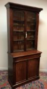 A Victorian mahogany bookcase cabinet with two arched glazed doors enclosing adjustable shelving on
