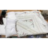 A box containing six white crochet covered scatter cushions,