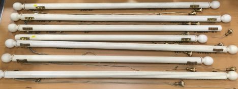 A collection of seven curtain runners with reeded poles and knob ends, various lengths,
