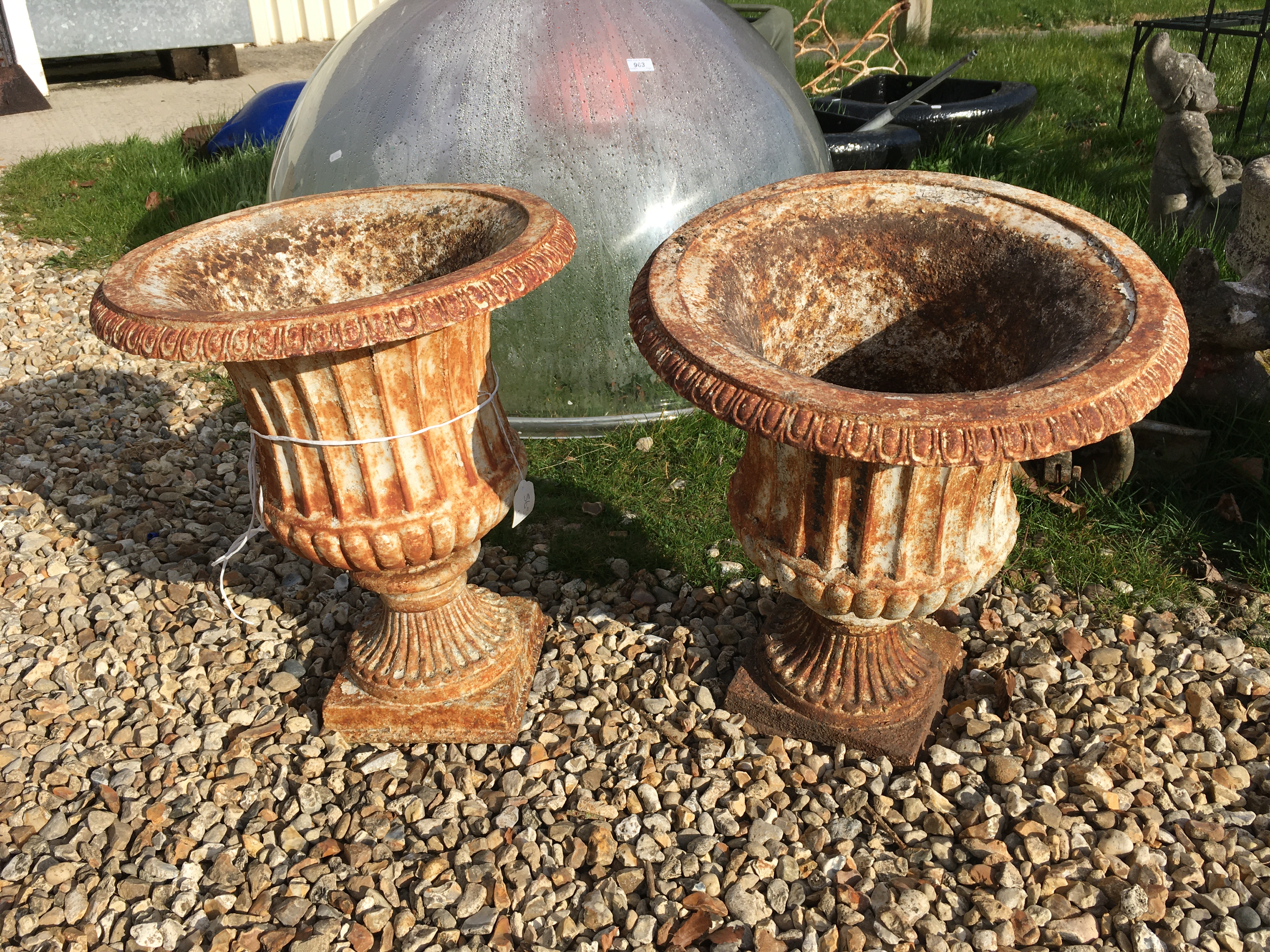 A pair of Victorian painted cast iron garden urns with egg and dart flared rims over fluted and