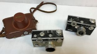 A collection of three Argus cameras including a black and chrome bodied Rangefinder (No.