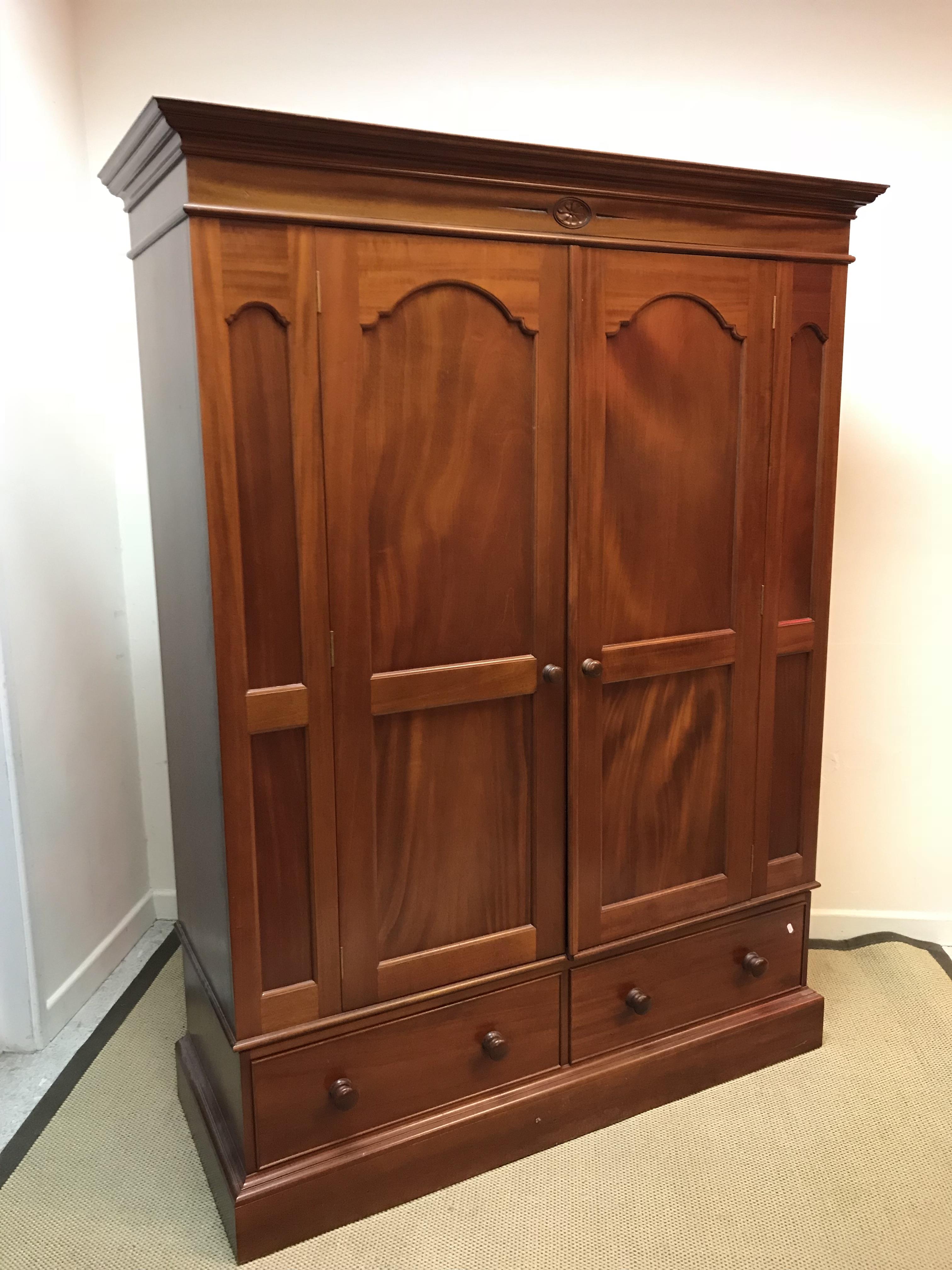 A modern mahogany double wardrobe with two drawer base 148 cm wide x 57 cm deep x 197.