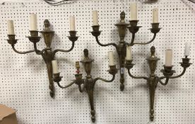 A set of four 20th Century brass three branch wall lights with acanthus decoration in the Regency
