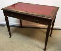 A circa 1900 rosewood writing table with tooled and gilded leather writing surface (covered with