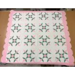 A 20th Century turkey tracks quilt in pink, white and green, with scalloped edge, 200 cm x 206 cm,