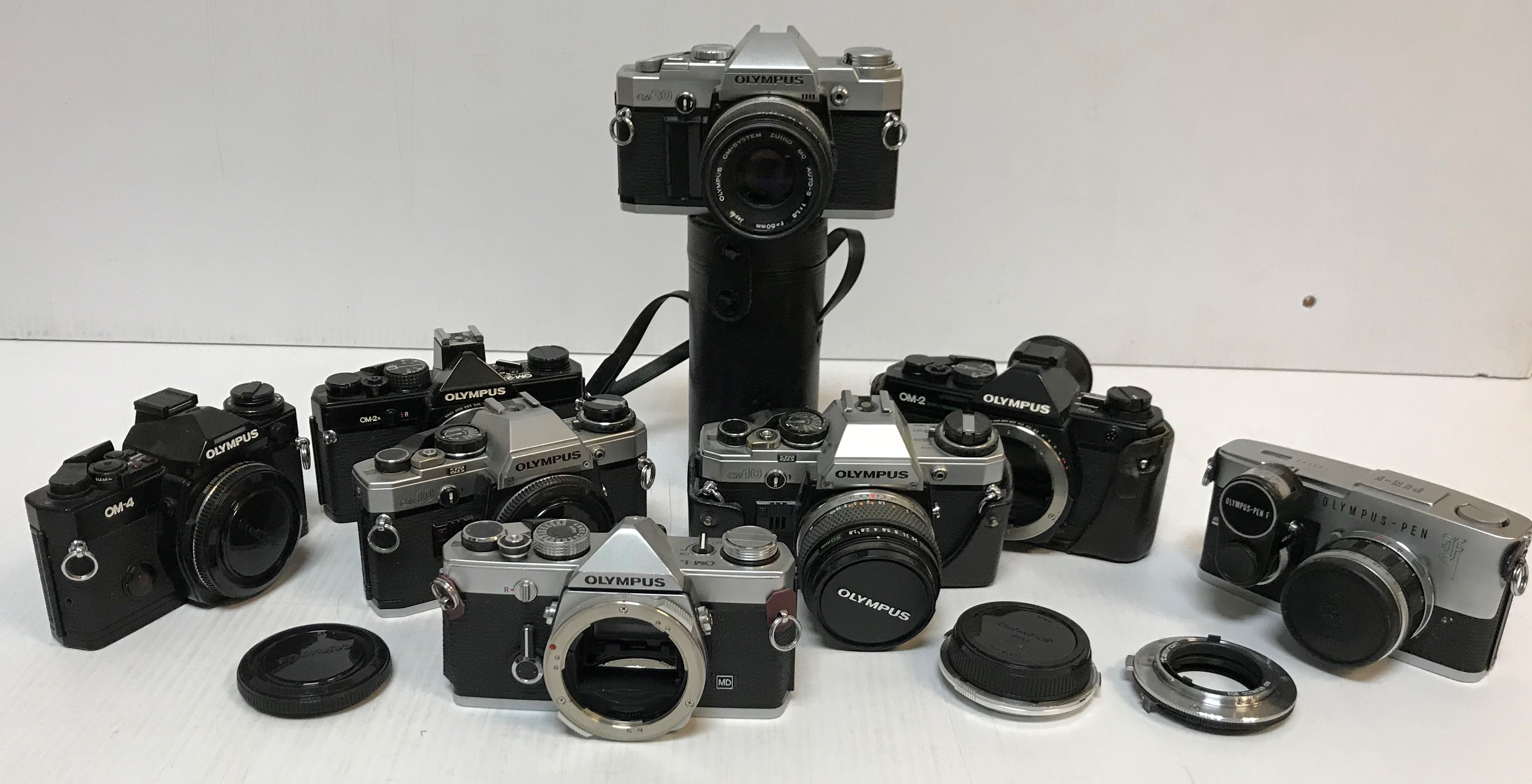 A collection of eight various Olympus cameras including OM-1N, OM2-Spot/Programme, OM-2 2N, OM10 x2,