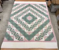 A modern Canadian patchwork quilt in white, pink and green,