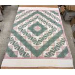 A modern Canadian patchwork quilt in white, pink and green,