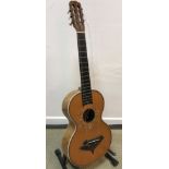 An early 20th Century acoustic guitar with mother of pearl inlaid floral decoration and birds eye